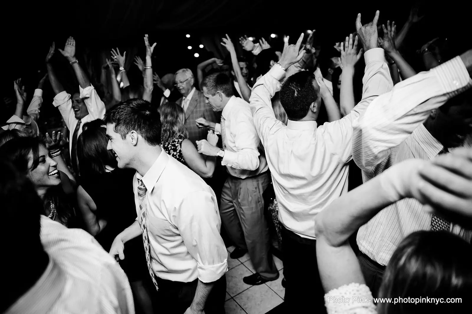 Black and white photograph of a crowded Finger Lakes wedding reception dance floor